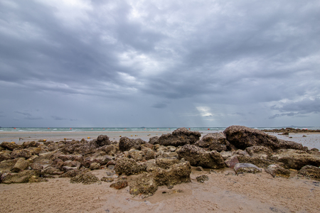 The rocks on the beach with rain cloud at island.の写真素材