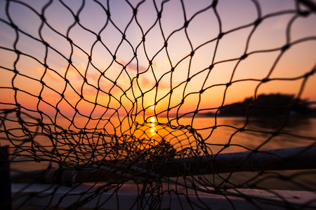 dip net in boat fishing on sunrise, sunset water.の写真素材