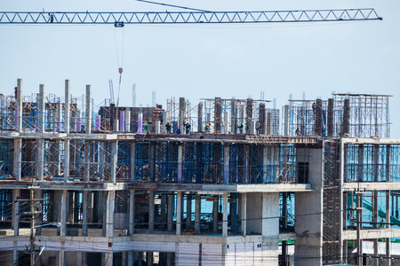 Crane and building construction site against blue skyの写真素材