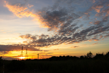 Mobile phone communication antenna tower with silhouette in sunset sky backgroundの写真素材