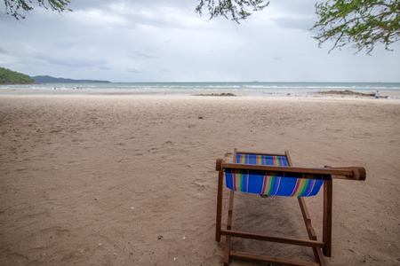 Beach chair on the beach at summer and rain cloud over the sea.の写真素材