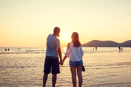 couple hand hold on the beach between sunset. Couple travel at the beach.の写真素材