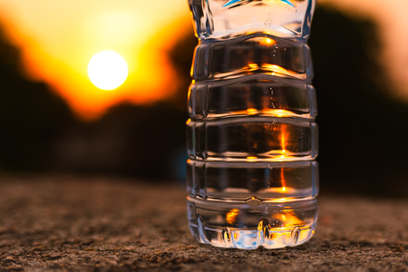 Pure water bottle on the ground at sunset.の写真素材