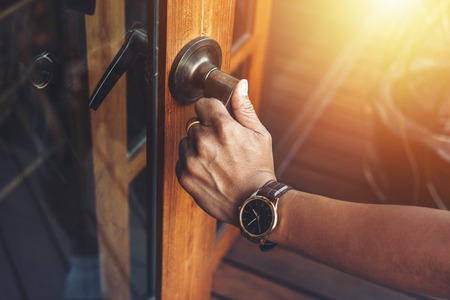Man hands open the wood door.の写真素材
