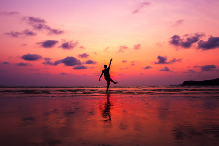 A man kick sea water and water splash at twilight sunset. Happy and relax on the beach.の写真素材