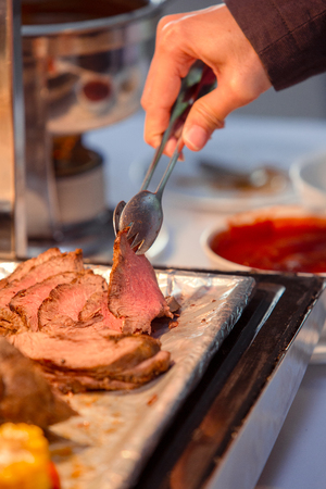 hand use tongs food with steak in tray.の写真素材
