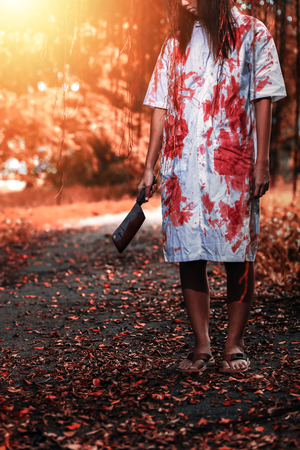 Woman holding knife with blood, halloween conceptの写真素材