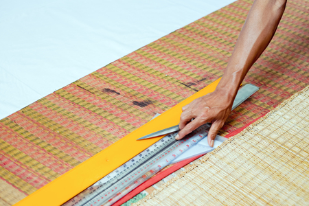 Scissors and ruler on the ground and hand working.の写真素材