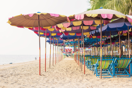 the beach color blue water and umbrella. the chair is on the sandの写真素材