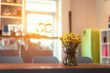 little yellow flower in jar on the table.の写真素材
