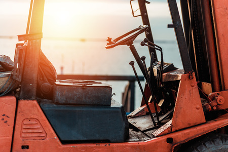 Old Forklift transporting cargo on a road near the sea with sunset time.の写真素材