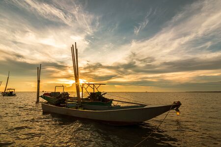 wood fishing boat in the sea and sunset.の写真素材