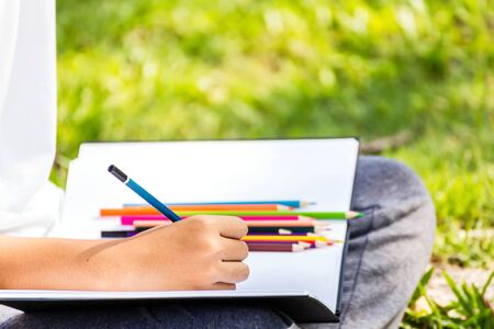 Student practice drawing by pencil in the park.The crayon is on the white paper.の写真素材