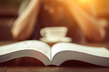 A book is on the table between tea times.の写真素材