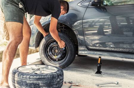 Change a flat car tire at car park with Tire maintenance, damaged car tyreの写真素材