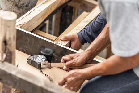 carpenter working at site construction. Measuring Tape on wood board.の写真素材