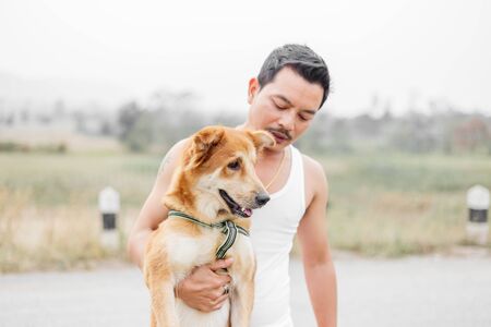 A man hold cute dog. A dog happy between travel.の写真素材