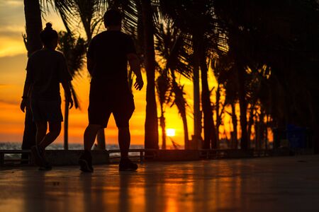 People running on the road near the beach and coconut tree with sunset.の写真素材