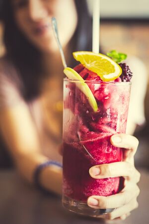 Women hold mulberry smoothie. Mulberry, Lemon and Mint in smoothie.の写真素材