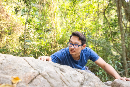 A man climb rock in the forest.の写真素材