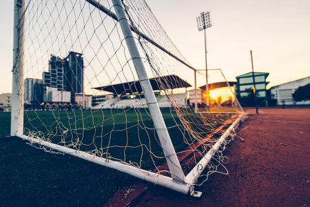 goal football at sport stadium and sunset.