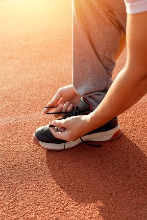 man enlacing sport shoes on track race.の写真素材
