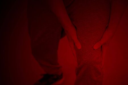 Athlete suffering form running knee or kneecap injury during outdoor workout.の写真素材