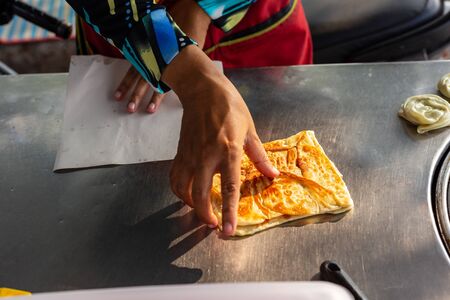 Hands of street vendor cooking Thai style sweet roti.の写真素材