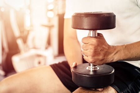 A man hold dumbbell at fitness gym.の写真素材