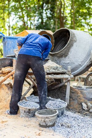 The workers are mixing cement in a cement mill.の写真素材