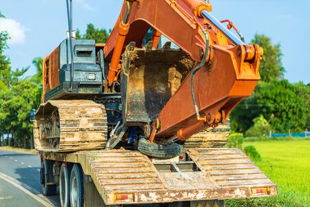 Backhoe excavator on truck  on the road between transport.の写真素材
