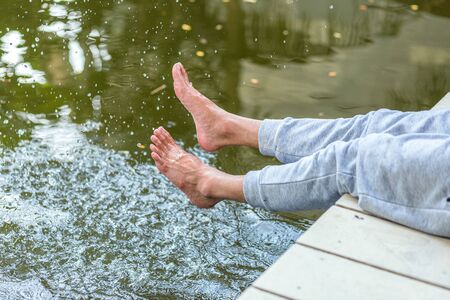 relax man at a lake having fun and splashing water in summerの写真素材