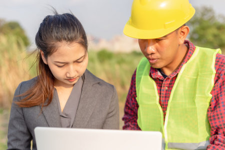 Businesswomen and foreman talking together. Engineer and manager teamwork and checking at site...