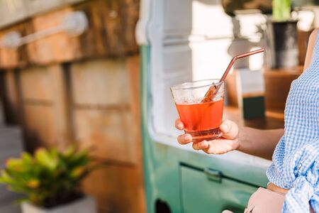 Hands hold Juicy strawberry mixed juicy peach. Drink refreshment at sunny day.の写真素材