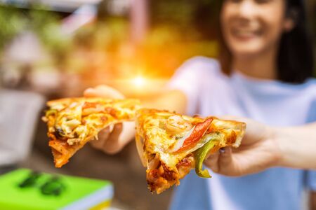 office people group taking and sharing pizza slices from box on table. Employees team workers eating together enjoy at work break, delivery service concept.の写真素材