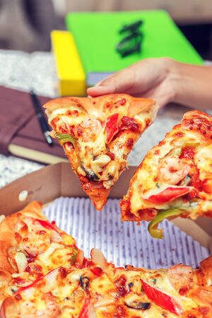 office people group taking and sharing pizza slices from box on table. Employees team workers eating together enjoy at work break, delivery service concept.の写真素材