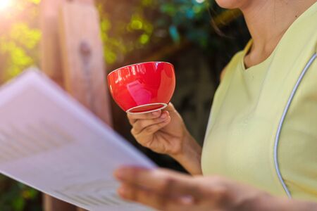 Businesswomen hold cup of coffee and reading paper.の写真素材