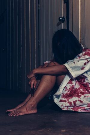 horror scence of women hold knife by hands with blood. Ghost women wear white dress stain blood at abandoned house
. Halloween conceptの写真素材