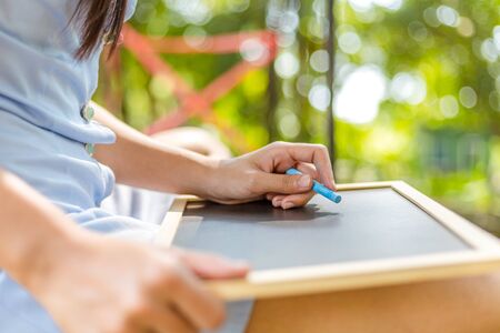 Hands use chalk for drawing, writing balckboard in the parks. Education, learning concept.の写真素材