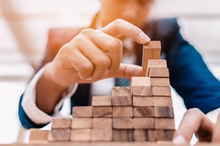 Ant eye view Male hand stacking wooden blocks. Business development and growth conceptの写真素材