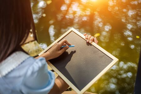 Hands use chalk for drawing, writing balckboard in the parks. Education, learning concept.の写真素材