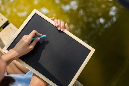 Hands use chalk for drawing, writing balckboard in the parks. Education, learning concept.の写真素材