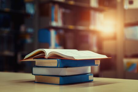 Open book on stack of books in library at school, university, college.の写真素材