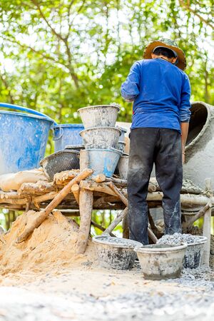 The workers are mixing cement in a cement mill.の写真素材