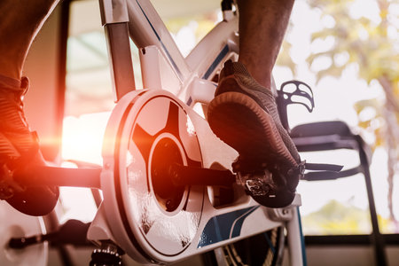 Fit man working out on exercise bike at the gym. Healthy and funny lifestyle concept.