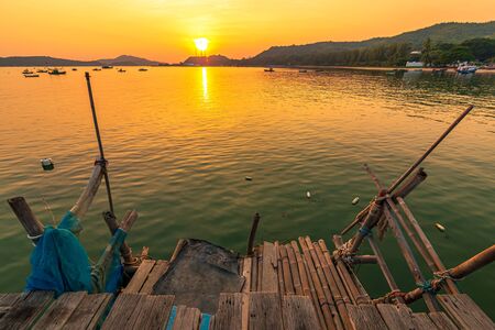 Wooden dock in the sea at sunset.の写真素材