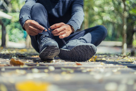 Man hands tying on wood bridge in the parks. Preparation for running.