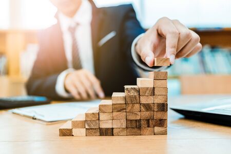 Male hand stacking wooden blocks. Business development and growth conceptの写真素材