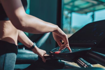 finger pressing on button of running machine in gymの写真素材