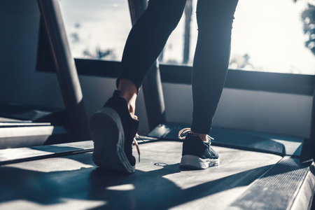 foot Fitness girl running on track treadmill, exercise, workout at fitness gym.